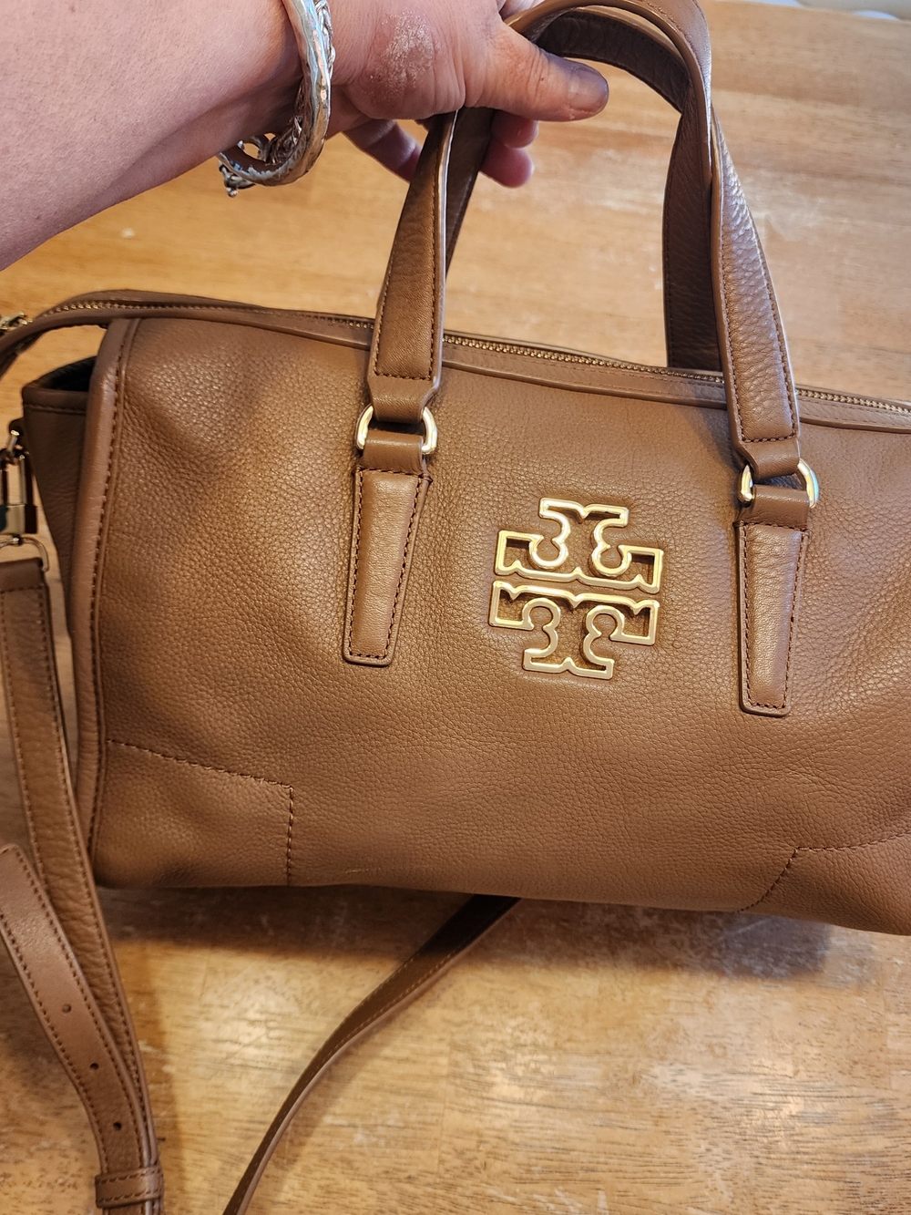 brown Tory Burch Britten satchel made of pebbled leather with a gold-tone cutout